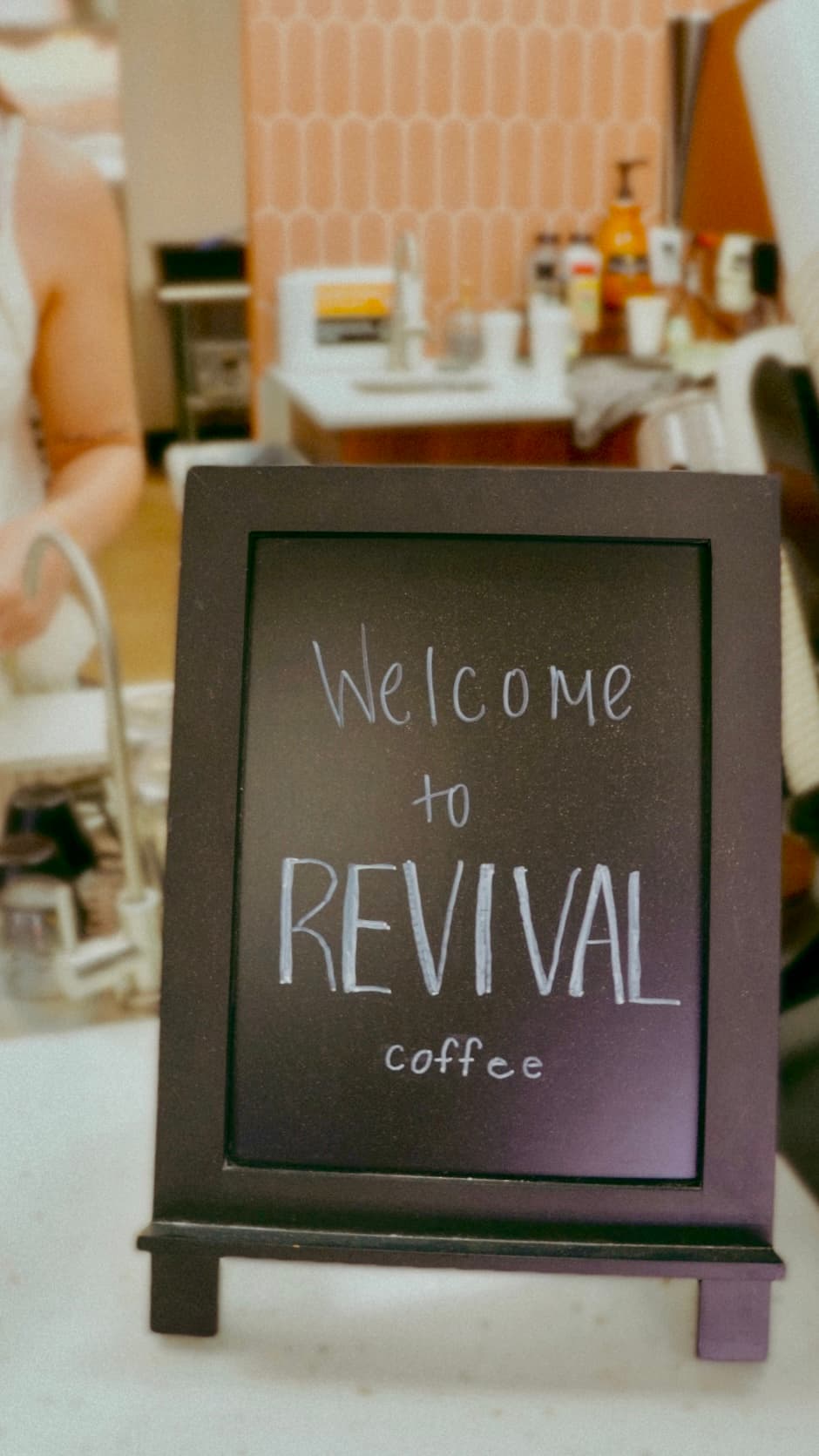 Welcome to Revival Coffee chalkboard sign with shop interior